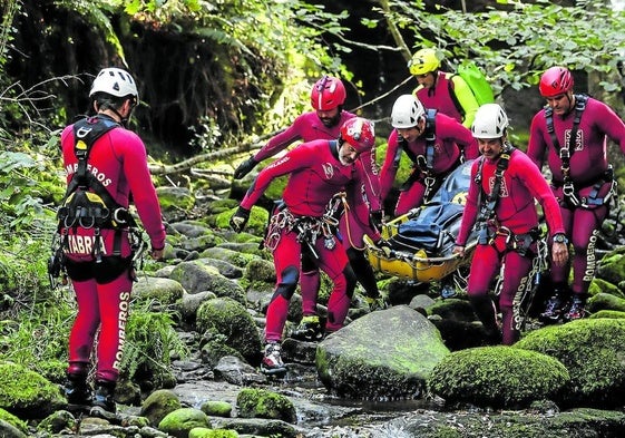 Especialistas del 112, en un ejercicio de rescate de un herido en descenso de barrancos en Vega de Pas.