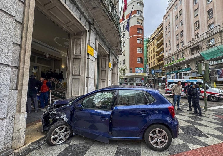 El Volkswagen azul accidentado, a las puertas del edificio de la Seguridad Social en pleno centro de Santander.