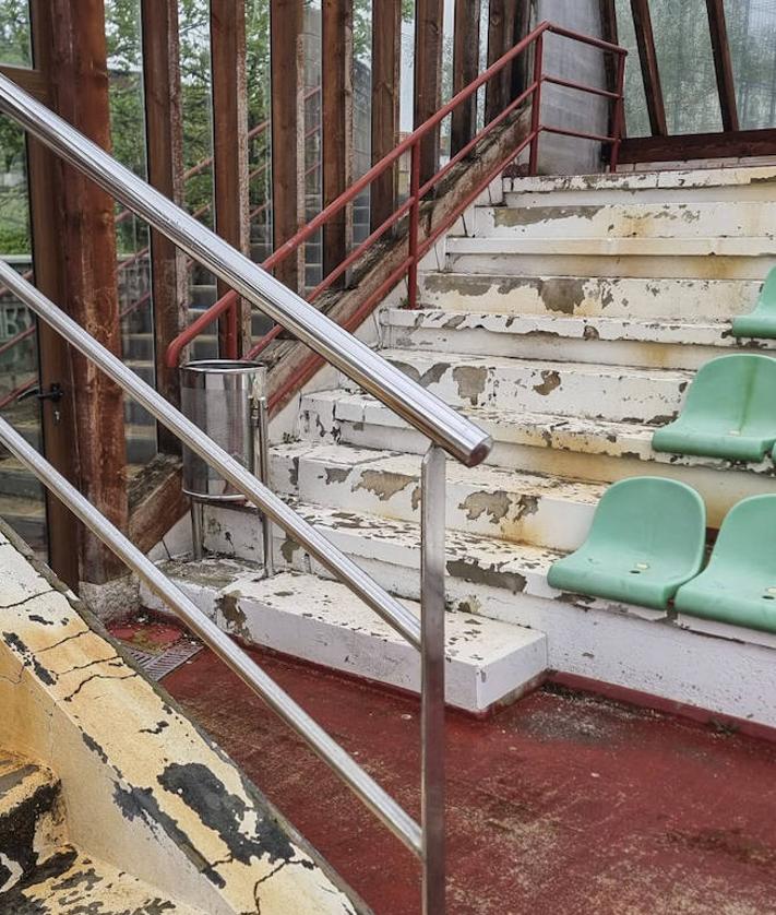 Imagen secundaria 2 - 1. El exterior de la bolera ha sufrido daños por vandalismo. | 2. El estado de deterioro llega a las escaleras y los asientos.