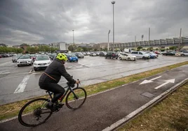Un ciclista circula por el carril bici ubicado junto al aparcamiento de los Campos de Sport de El Sardinero.