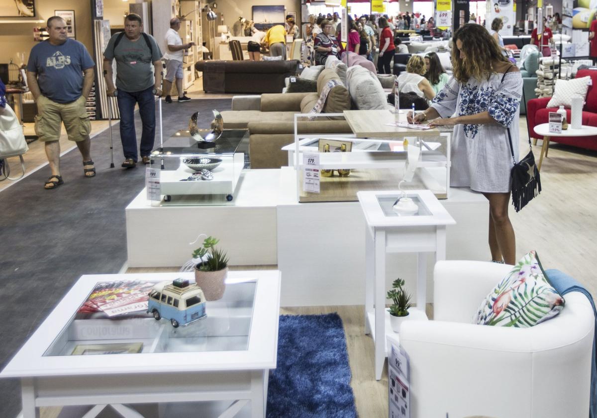 Varios clientes pasean por una tienda de muebles de Cantabria.