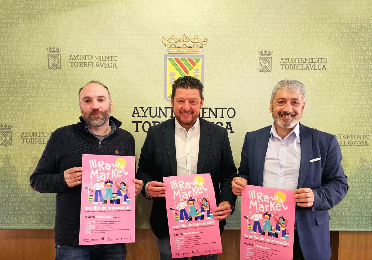 Javier Enríquez, Jesús Sánchez y Jesús García sostienen el cartel del Raw Market, este lunes, en Torrelavega.