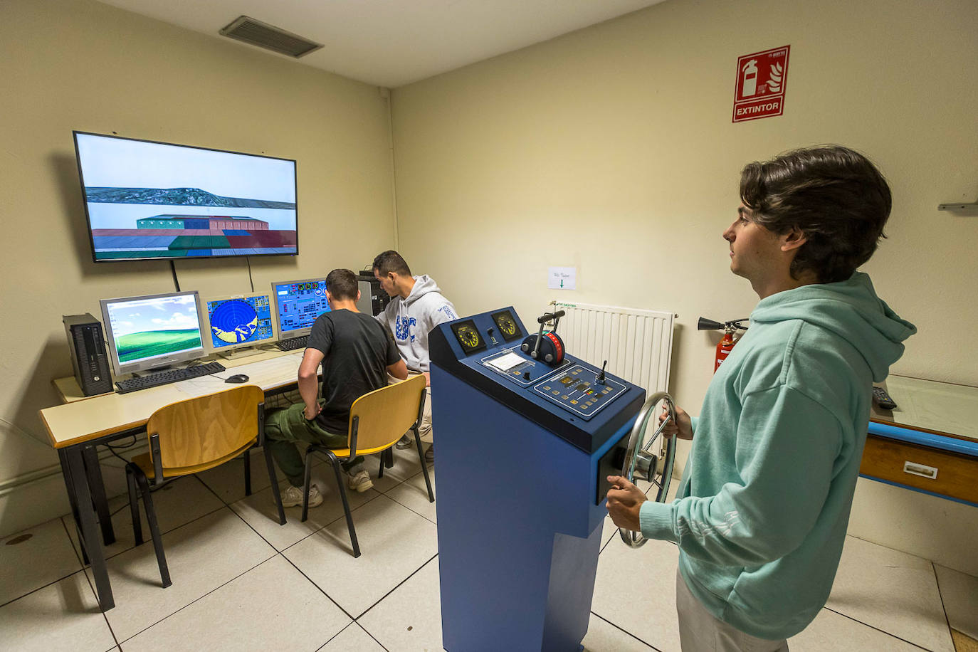 Tres alumnos practican con simuladores en la Escuela Técnica Superior de Náutica.