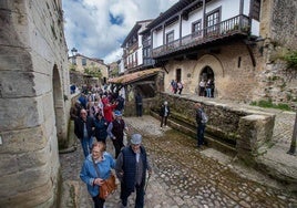 Una excursión de turistas visita las calles de Santillana del Mar.