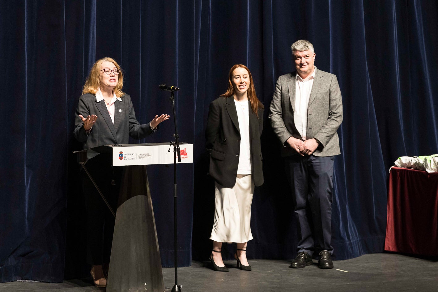 Los consejeros de Cultura y Economía, junto a la presentadora de la entrega de distinciones a los participantes.