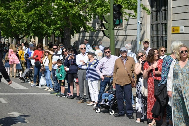 Peatones atentos al paso de la Sección de Movimientos Floreados y la unidad de Música por el centro de la ciudad.