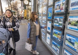 Una mujer consulta anuncios de una inmobiliaria de Santander.