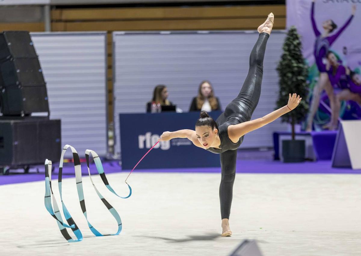 Imagen secundaria 1 - 1. La gimnasta cántabra Attenery Boix ejecuta una de las dificultades de su ejercicio de cinta sobre el tapiz. | 2. Desde las gradas del Palacio de los Deportes, gimnastas y aficionados no perdieron detalle de la Copa.