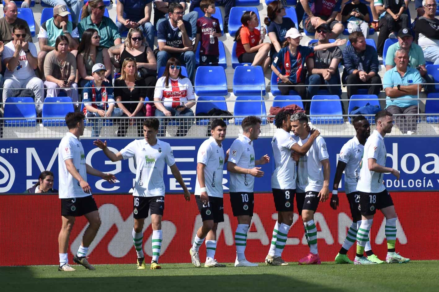 Los jugadores del Racing se felicitan por el tanto que les puso por delante en El Alcoraz. 