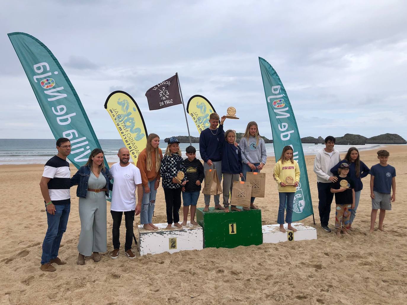 La primera jornada de competición se clausuró con la entrega de premios en la misma playa, a la que acudió la alcaldesa de Noja, Mireia Maza, acompañada por el concejal de Seguridad, Roberto Ruiz, el de Turismo, Francisco Javier Velasco, y el gerente de la Escuela de Surf Ris, Enrique Segovia