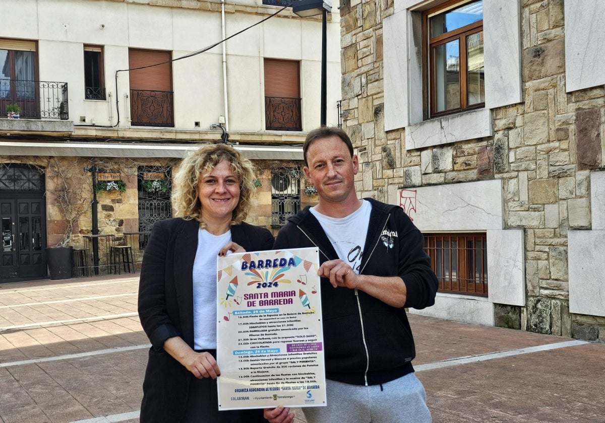 La edil de Festejos, Patricia Portilla, y el presidente de la Asociación de Vecinos de Barreda, José Gómez, sostienen el cartel de las fiestas, este miércoles, en Torrelavega.