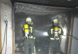 Los bomberos intervienen en el interior del garaje incendiado, totalmente calcinado.