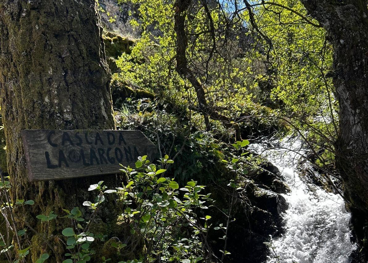 Imagen secundaria 1 - Arriba vista general desde un alto de la ruta. Abajo, señal hacia la cascada La Largona. A la derecha, una zona de la ruta por la que hay que ayudarse de una cuerda para subir o bajar.