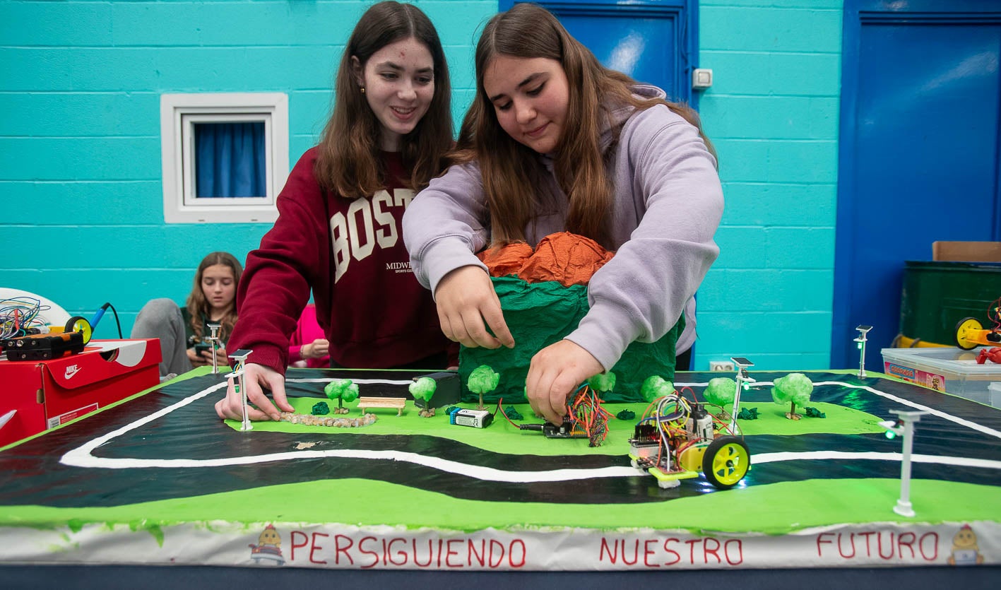 Dos alumnas del IES Ricardo Bernardo acomodan el circuito por el que circula el vehículo autónomo que han diseñado. Con este proyecto han querido poner el foco en la eficiencia energética. 