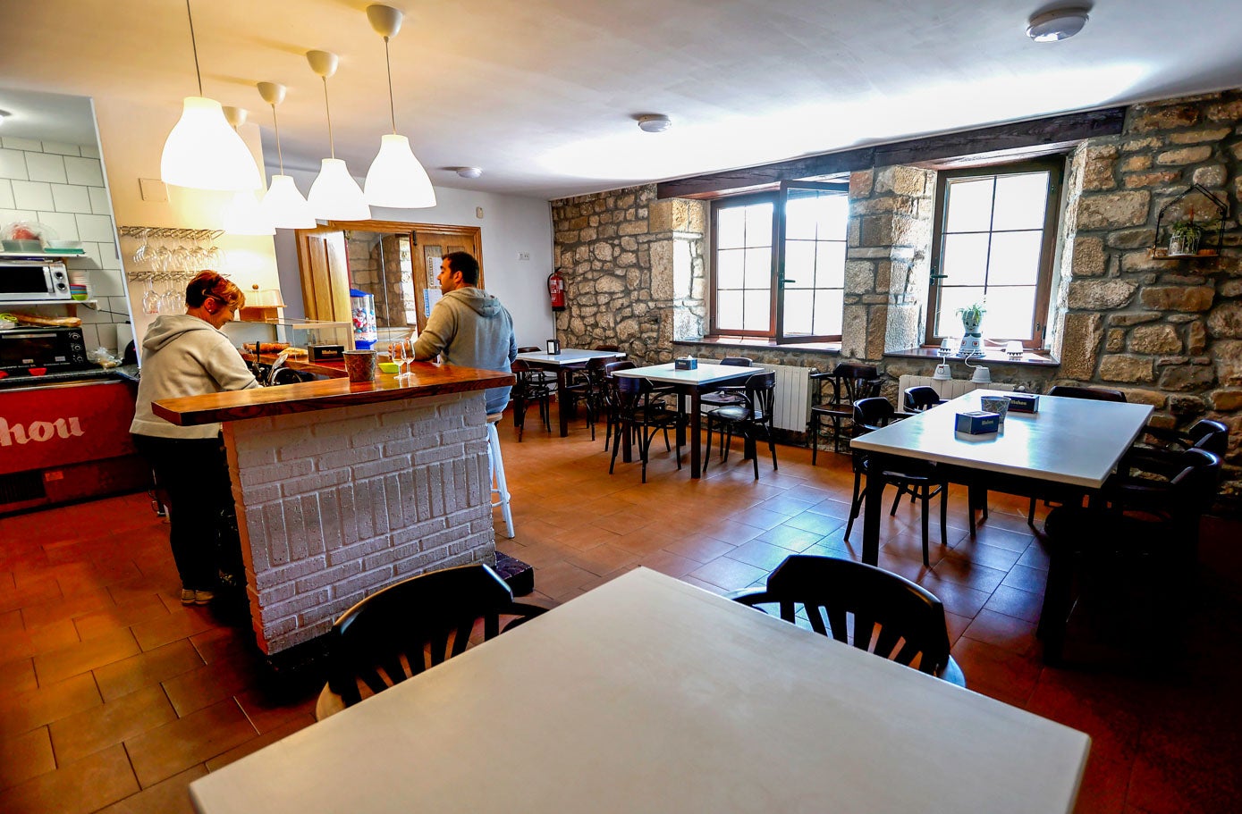 Carmen Fernández atiende un cliente en el bar de la localidad, un local de propiedad municipal que en breve también se convertirá en restaurante.