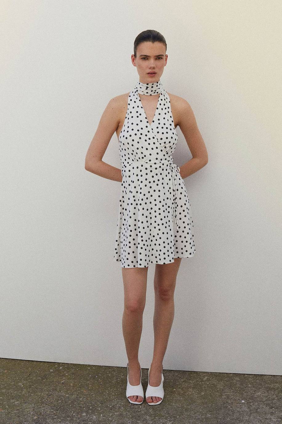 Mini vestido de lunares con escote 'halter' y lazada en el cuello. 29.99 euros en Sfera. 