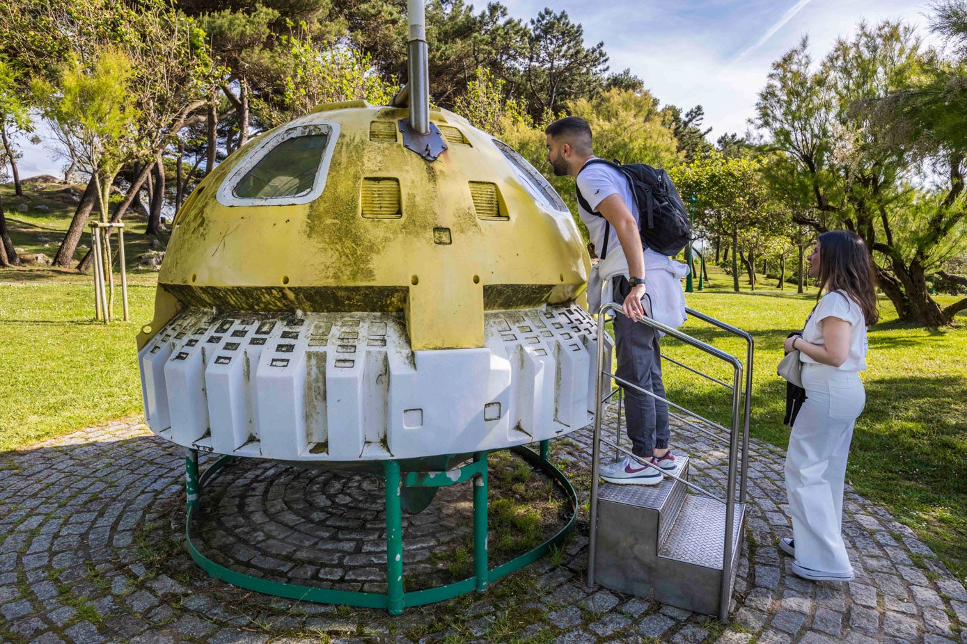 Dos turistas observan la burbuja de salvamento de Vital Alsar, que acumula suciedad.