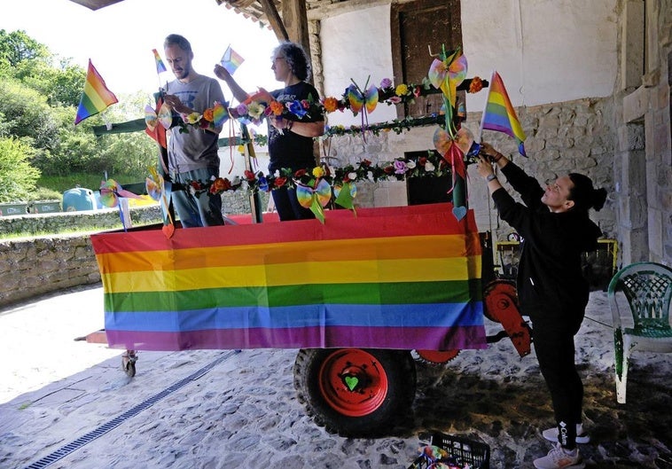 Tres de los organizadores preparan el tractor para participar en el desfile de mañana.