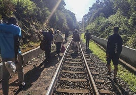 Un grupo de personas abandona la vía ferroviaria a pie en Beranga