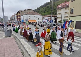 Un momento del desfile de agrupaciones y bandas por las calles de Unquera