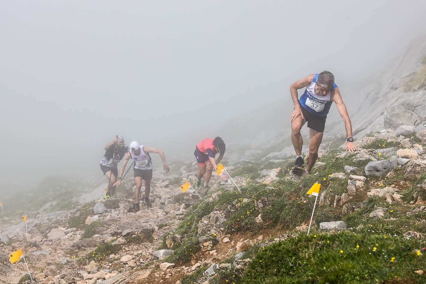 Varios participantes, en pleno esfuerzo entre la niebla en el Kilómetro Vertical de Fuente Dé.