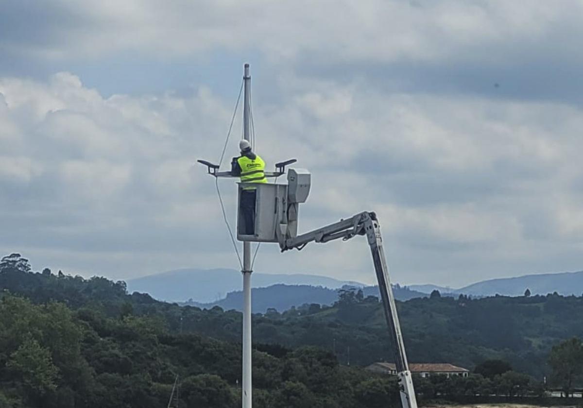 Un operario accede a un punto de luz en una grúa.