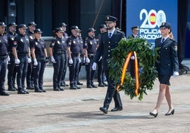 Dos agentes portan el ramo de flores para honrar a los compañeros caídos.