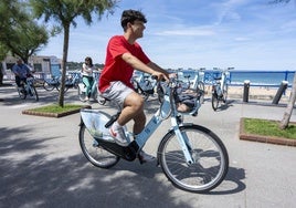 El Sardinero. Un usuario utiliza la bicicleta municipal en la parada de la Plaza de Italia.