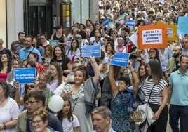 Los enfermeros y enfermeras asistentes a la protesta muestran sus demandas escritas en un momento de la manifestación.