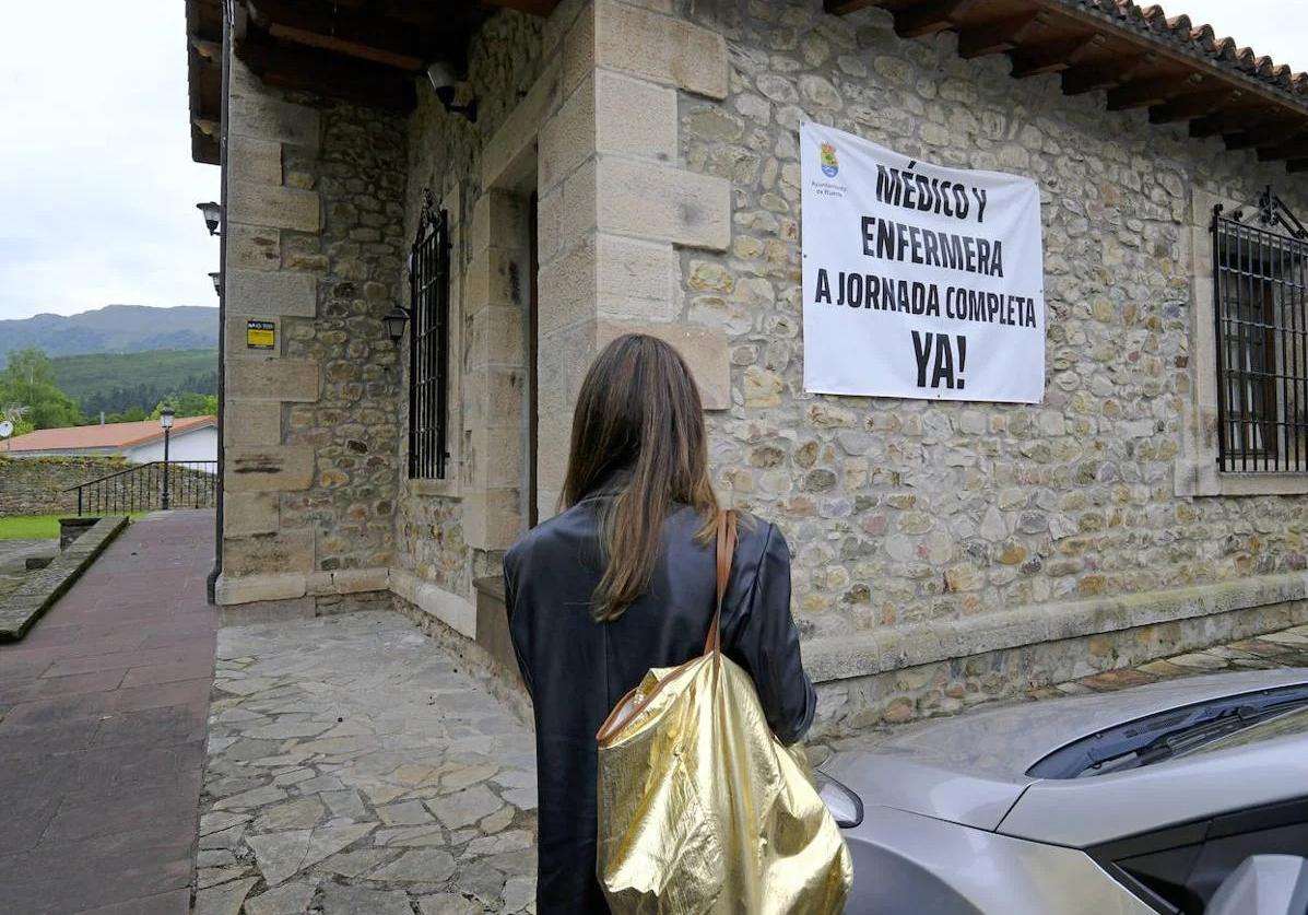 Una pancarta en la que se pide personal sanitario a jornada completa cuelga de la fachada del consultorio de Ruente.