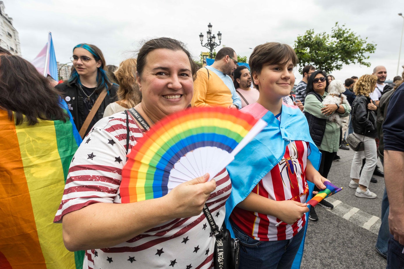 Una mujer enseña su abanico con el dibujo de la bandera del arcoíris del colectivo.