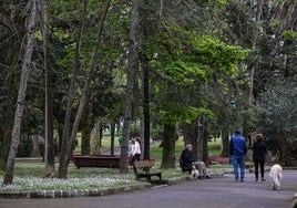 Vecinos caminan por el parque Manuel Barquín, esta primavera, en Torrelavega.