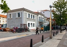 Vecinos caminan frente al edificio de La Llama, que atraviesa las últimas fases de su reforma, esta semana, en Torrelavega.