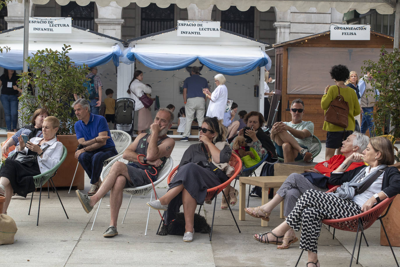 Algunos visitantes en al area de descanso y lectura habilitada en la plaza