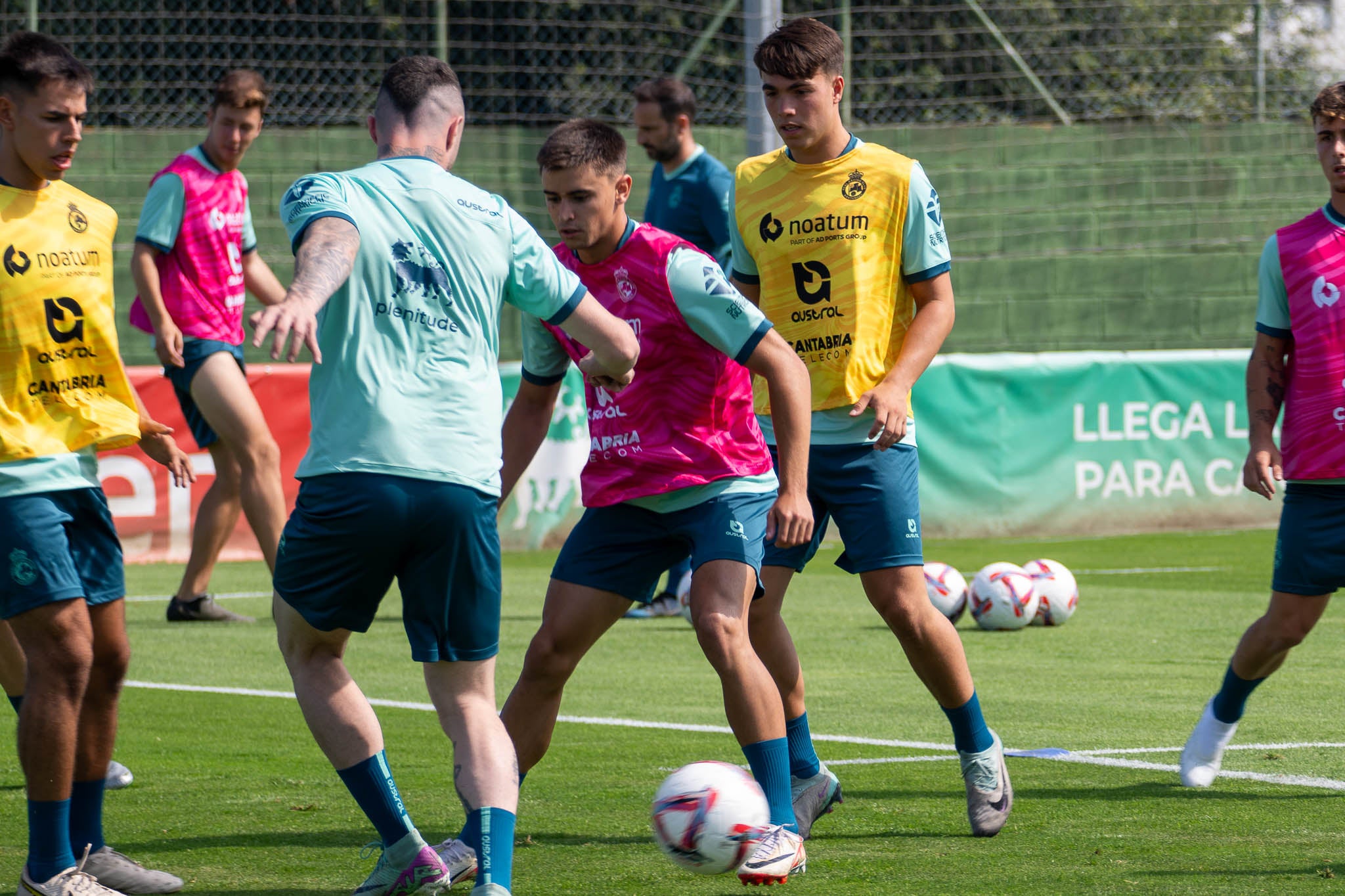 Mario García, con el peto rosa, conduce la pelota en el entrenamiento.