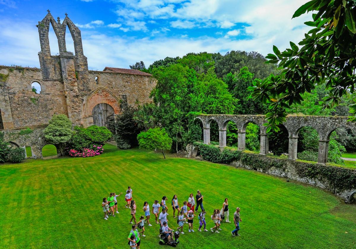 Los niños del campamento de verano, junto a la alcaldesa de San Vicente y un guía, visitan el antiguo claustro del convento.