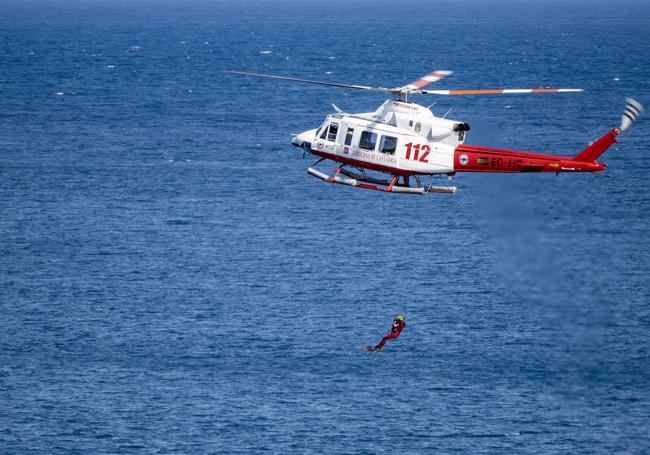 El helicóptero rescata a una persona en el mar.