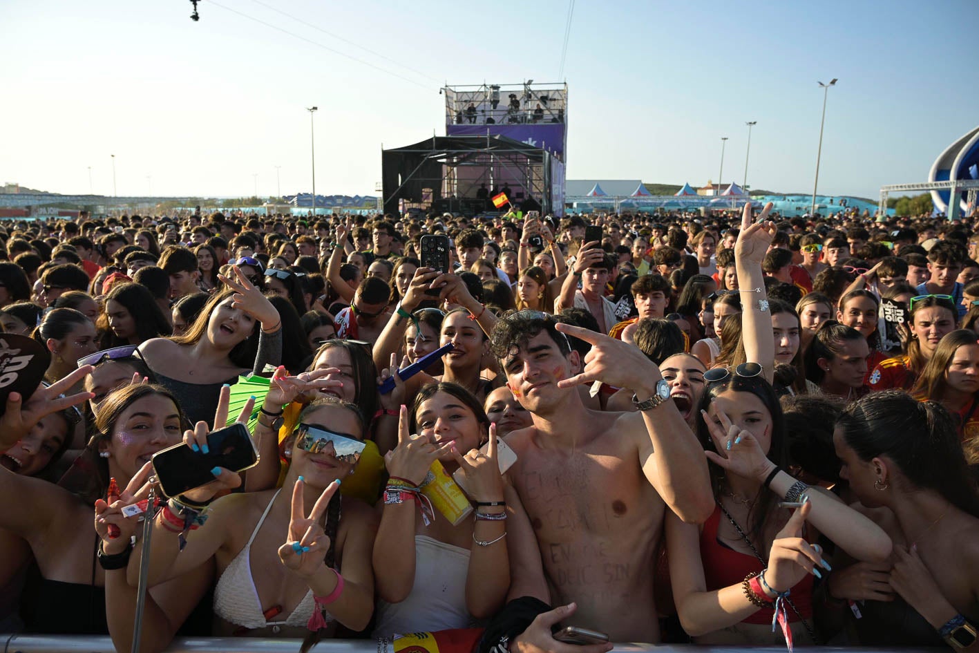 Miles de jóvenes posan en la primera fila del escenario.