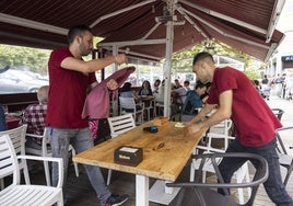 Unos camareros preparan una terraza de hostelería en la zona de El Sardinero, en Santander.