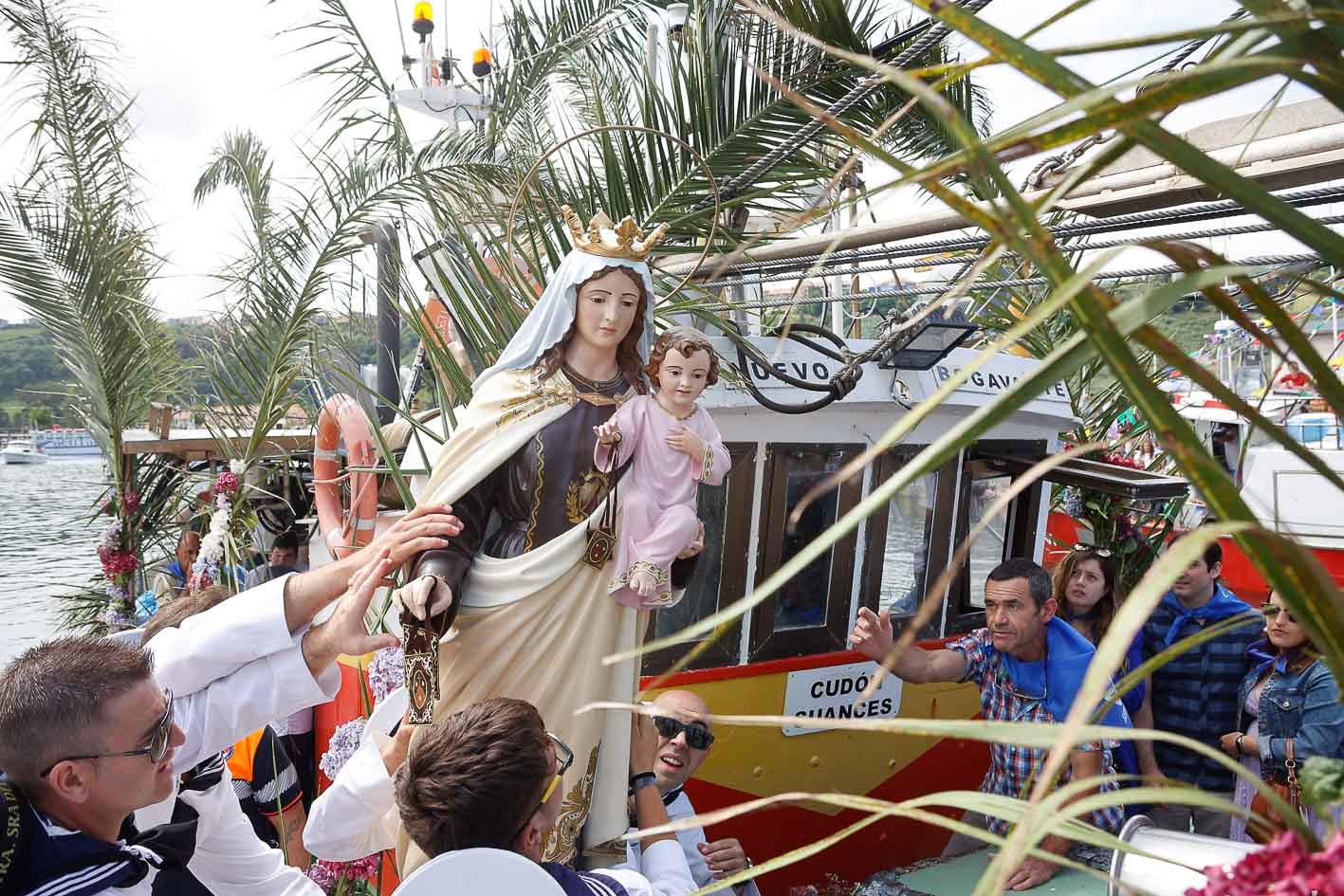 Momento en que la virgen sube el barco para iniciar la procesión marítima.