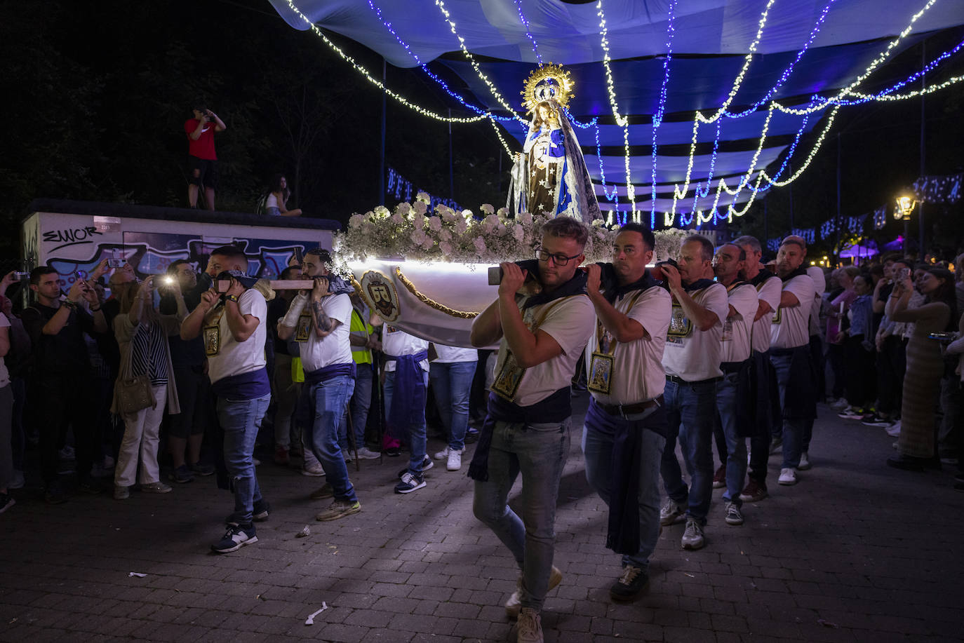 Catorce costaleros cargan a la Virgen del Carmen en procesión. 