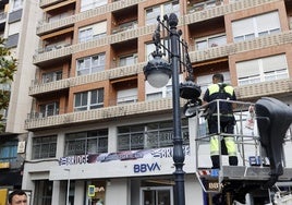 Un operario repara una farola en Torrelavega.