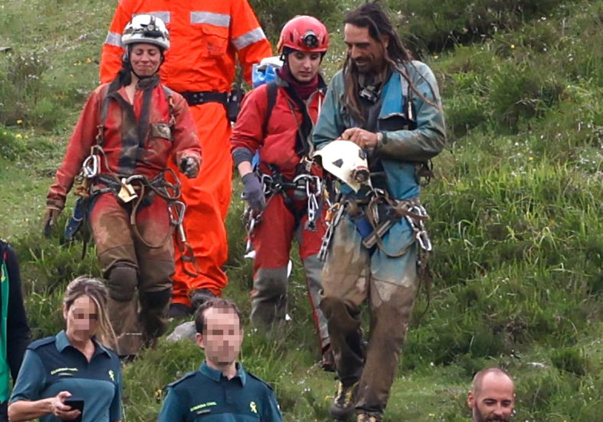 Paloma Bombín y Alfonso Urrutia salen de la cueva acompañados de efectivos implicados en el rescate.