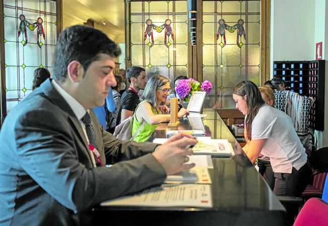 Los asistentes esperan en la entrada al reparto de acreditaciones.