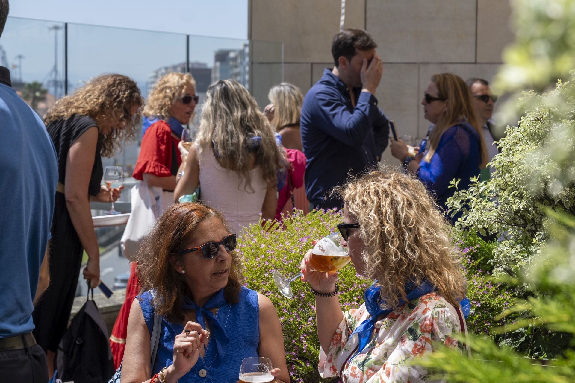 Invitados disfrutando de sus cervecitas y vinos para combatir el calor y ponerse al día.