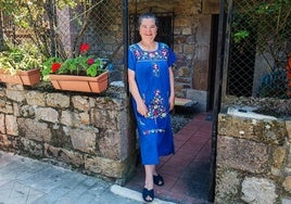 Jacinta González, en la puerta del patio de su casa de Garabandal, donde está pasando las vacaciones de verano. En la mano, el crucifijo «que besó la Virgen».