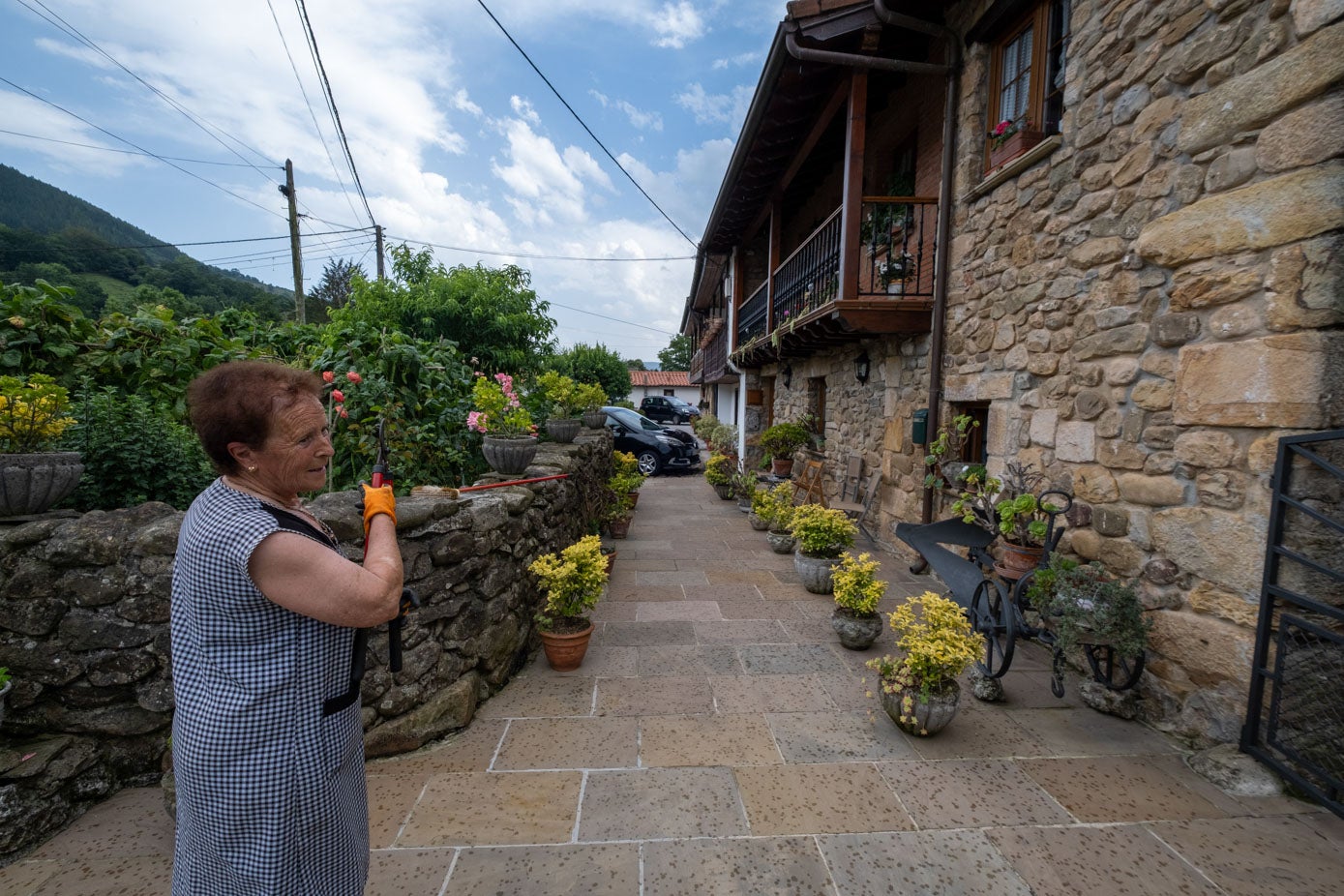 Una vecina junto a una de las viviendas de piedra.