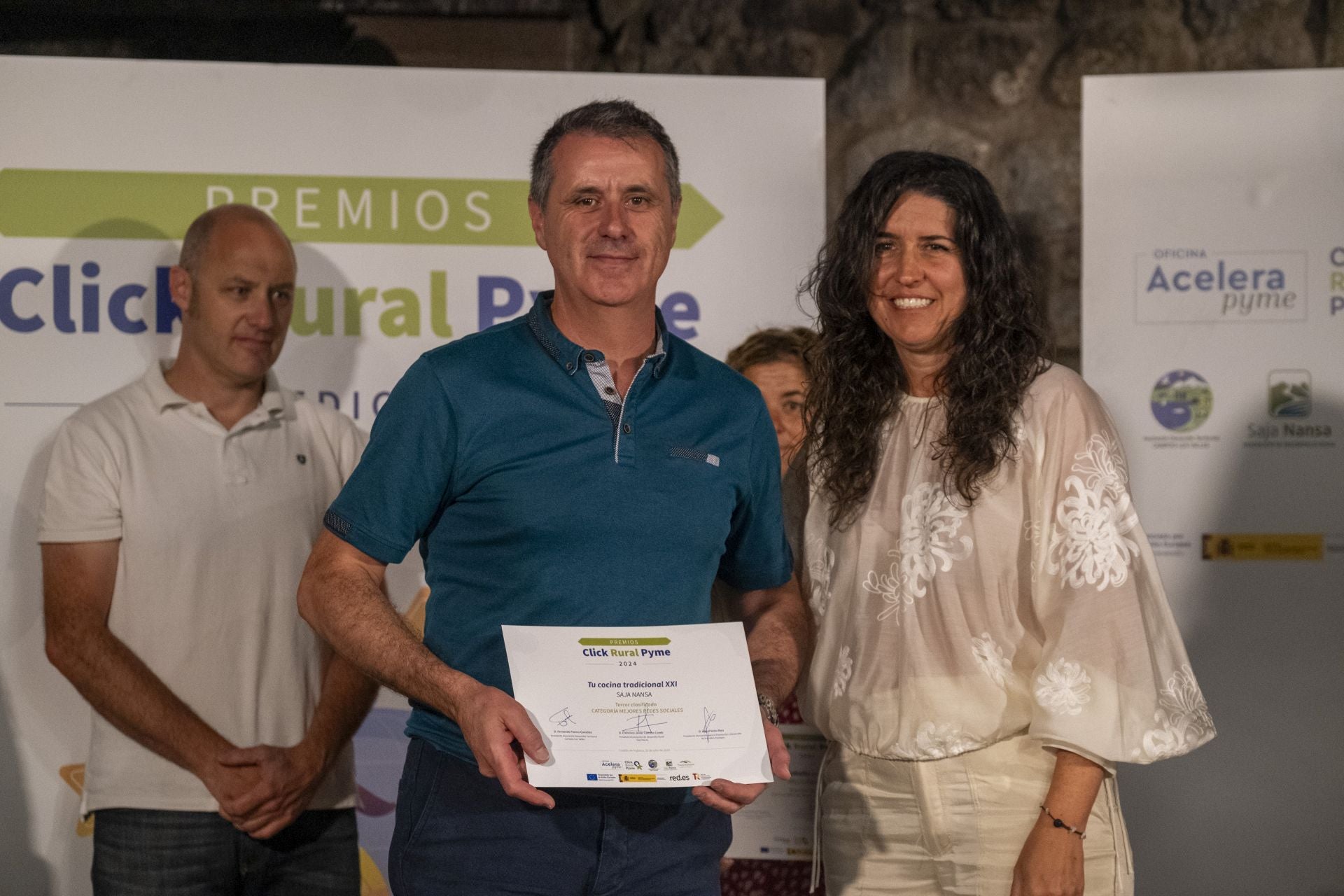 Juan Carlos González, socio propietario de Tu cocina tradicional, recibe el diploma que le acredita como tercer clasificado en 'Mejores redes sociales' que le entrega Ana Manrique, gerente del Grupo de Acción Local de Valles Pasiegos.