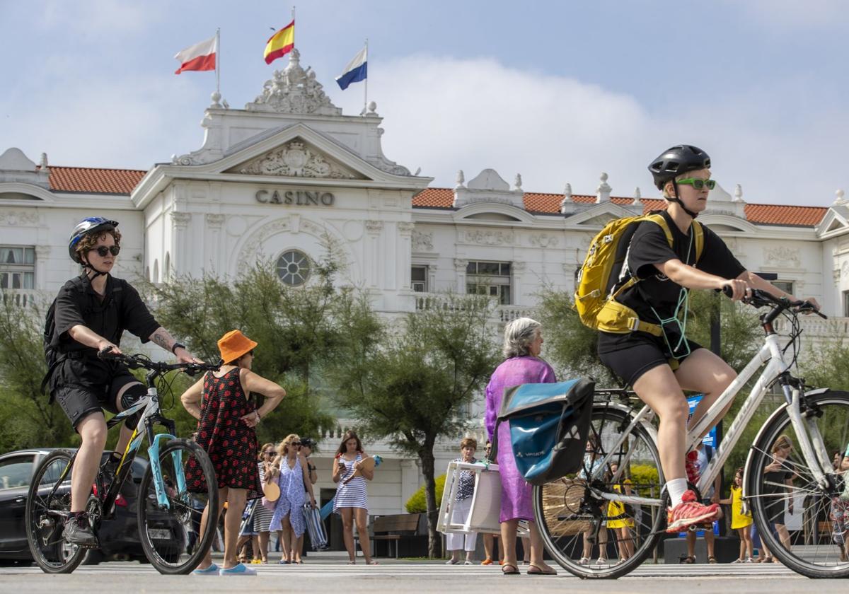 Dos turistas montan en bicicleta por el carril bici del Sardinero.