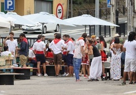 Varias personas en las fiestas del Día de Cantabria en la terraza de un bar.